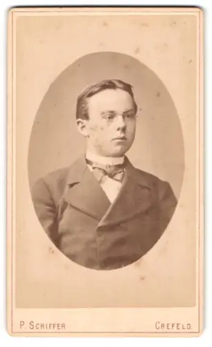 Fotografie P. Schiffer, Crefeld, Brustportrait junger Mann im Anzug mit Fliege und Brille