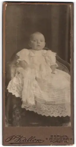 Fotografie P. Zallow, Berlin-Rixdorf, Portrait niedliches Baby im weissen Kleid auf Stuhl sitzend