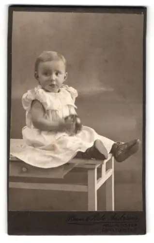 Fotografie Heinr. & Kate Andresen, Neumünster, Christianstr. 7, Kleines Kind auf Tisch sitzend