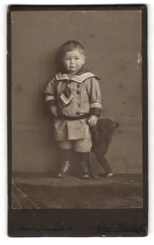 Fotografie Alfred Bischoff, Jena, Johannisplatz 25, Kleinkind im Matrosenanzug mit Spielzeug