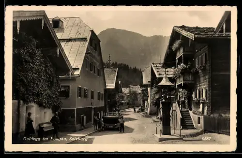 AK Goldegg im Pongau, Dorfstrasse mit Häusern und Bergpanorama, Turmbrunnen