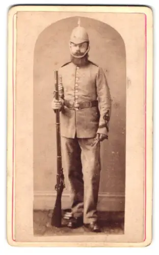 Fotografie J. Collis, Chard, Fore Street, Porträt eines britischen Kolonial-Soldaten mit Gewehr in Uniform