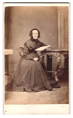 Fotografie Galbraith, Dundalk, Ältere Frau mit Buch am Tisch