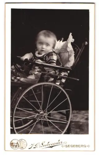 Fotografie J. G. Lubeseder, Segeberg, Kirchstrasse 34, Kind in kariertem Kleid im Kinderwagen
