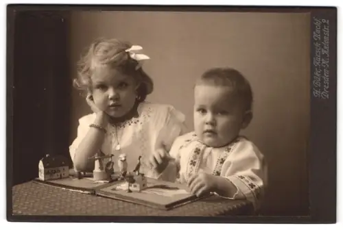 Fotografie H. Bähr, Dresden, Antonstr. 2, Kinder am Tisch mit Bilderbuch und Holzfiguren