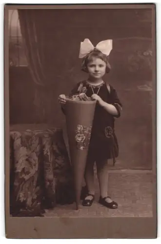 Fotografie unbekannter Fotograf und Ort, Ruth mit Schultüte im Atelier, 6 1/2 Jahre alt