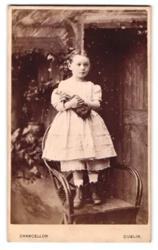 Fotografie Chancellor, Dublin, Lower Sackville Street 55, Kind mit Puppe auf Stuhl