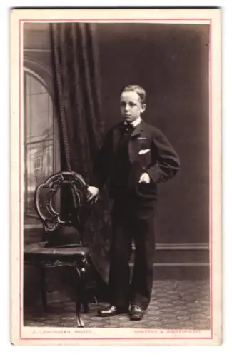 Fotografie J. Lancaster, Chester, Grosvenor Street, Eleganter Junge mit Stuhl
