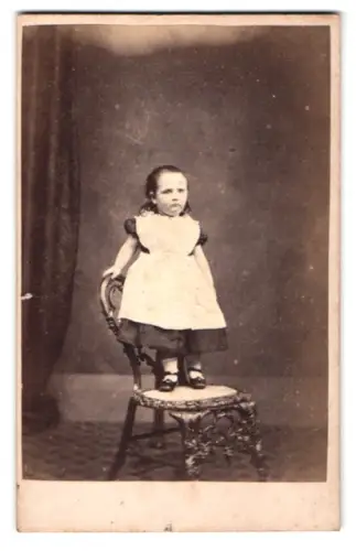 Fotografie Gallbraith, Dundalk, Kleines Mädchen auf einem Stuhl stehend