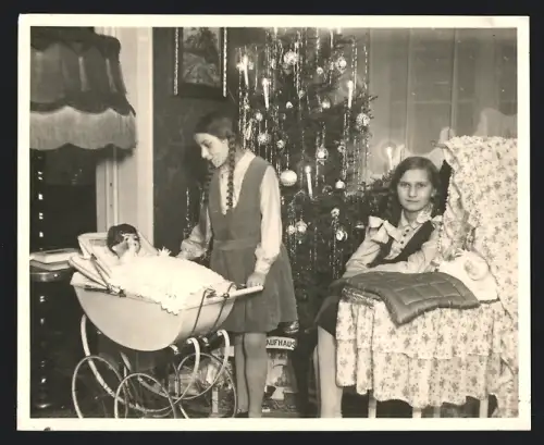 Fotografie Weihnachten, Mädchen mit Zöpfen freuen sich über neue Puppen & Puppenwagen