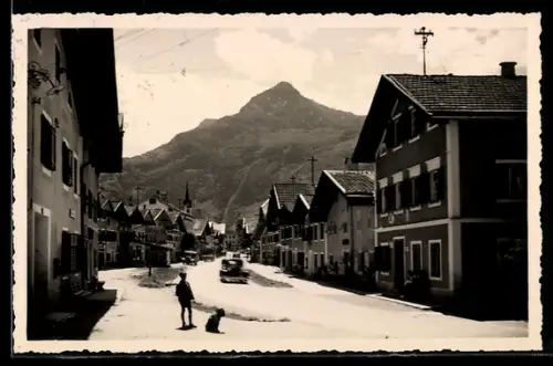 AK Golling, Hauptstrasse mit Bergpanorama und Kirchturm