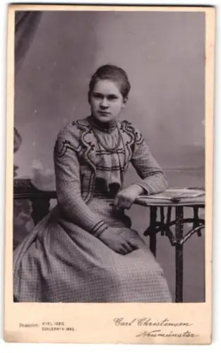 Fotografie Carl Christensen, Neumünster, Porträt einer jungen Frau am Tisch