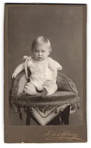 Fotografie Hermann Wolffberg, Rixdorf, Bergstrasse 9, Porträt eines Kleinkindes auf einem Polsterstuhl