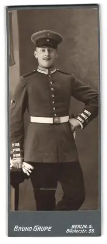 Fotografie Bruno Grupe, Berlin, Blücherstr. 56, Garde-Unteroffizier in Uniform mit Schirmmütze und Bajonett