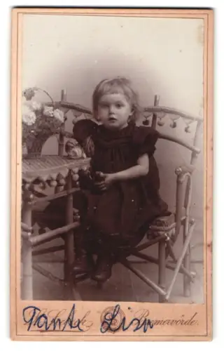 Fotografie L. Seebeck, Bremervörde, Kind sitzt auf Stuhl, Tante Lisa