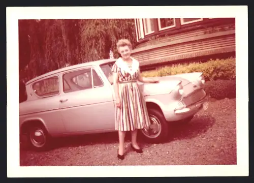 Fotografie Auto Ford Anglia, Hausfrau neben PKW stehend