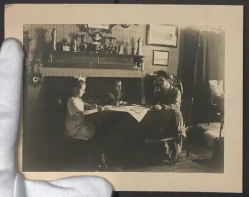 Fotografie unbekannter Fotograf und Ort, Zwei Kinder und ihre Mutter beim Memory-Spiel