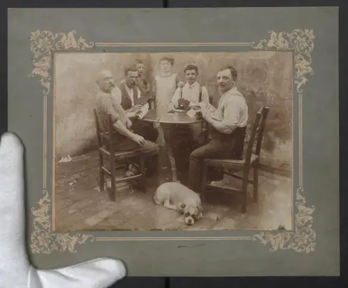 Fotografie unbekannter Fotograf und Ort, Gruppe mit Hund beim Kartenspiel an einem Tisch sitzend, Grossformat 22 x 27cm
