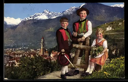 AK Meran, Drei Südtiroler Kinder stehen in Tracht vor einer italienischen Stadt
