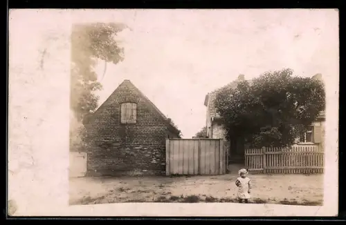 Foto-AK Hönow, Kleinkind auf der Strasse vor einem Haus