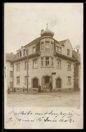Foto-AK Winnenden, Gruppe vor einem mehrstöckigen Gebäude am Strasseneck