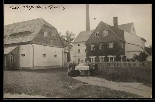 Foto-AK Kleinschweidnitz, Personen an einem Tisch vor dem Mühlenwerk
