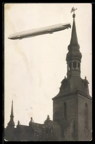 Foto-AK Wolfenbüttel, Zeppelin im Fluge über der Marienkirche