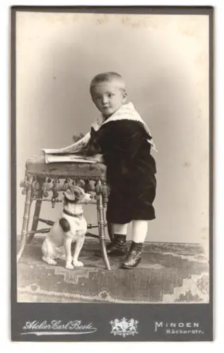 Fotografie Carl Beste, Minden, Bäckerstr. 13, Kind mit Hundefigur neben Hocker