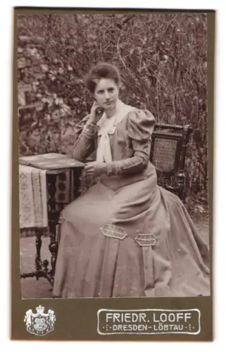 Fotografie Friedr. Looff, Dresden-Löbtau, Sitzende Dame an einem Tisch