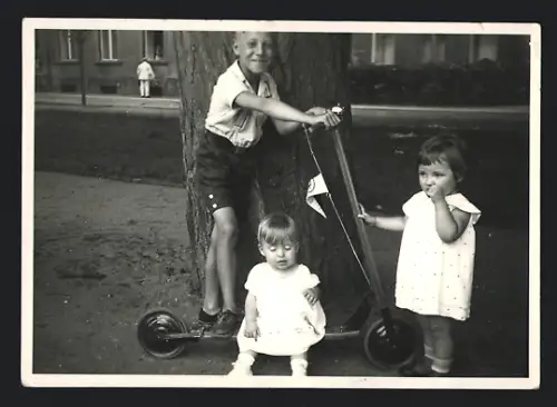 Fotografie Schuhmann, Schwedt / Oder, Knabe mit Tretroller nebst kleinen Mädchen