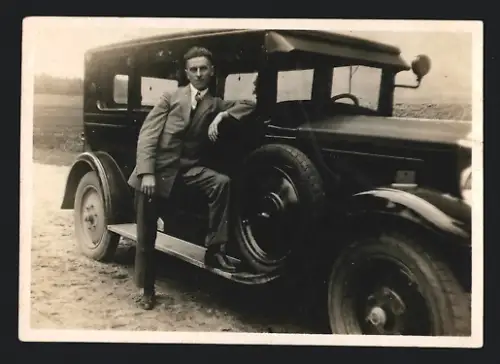 Fotografie Auto Limousine, lässiger Bursche im Anzug auf Trittbrett stehend