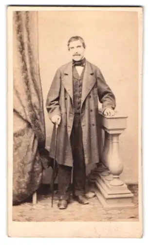 Fotografie unbekannter Fotograf und Ort, Mann in elegantem Mantel mit Gehstock