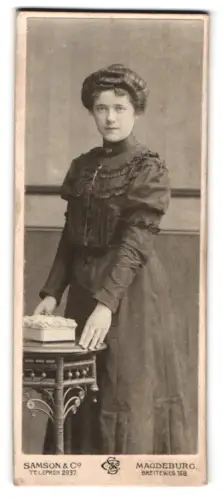 Fotografie Samson & Co, Magdeburg, Breiteweg 168, Frau im Rüschenkleid neben einem Tisch
