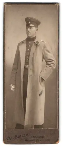 Fotografie Carl Müller, Hamburg, Hoheluft-Chaussee 35, Soldat in Uniform mit Mantel und Schirmmütze