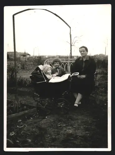 Fotografie Mutter & Tochter mit grosser Puppe im Kinderwagen