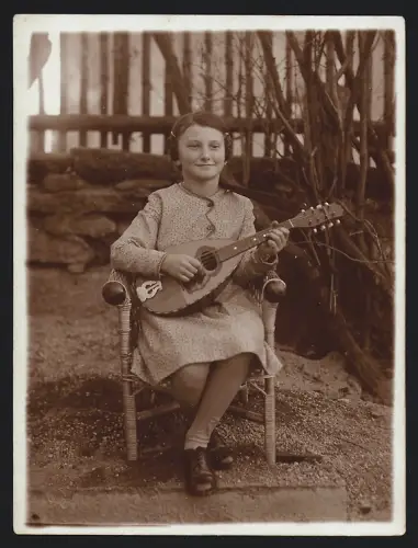 Fotografie Mädchen spieltr auf Saiteninstrument / Mandoline