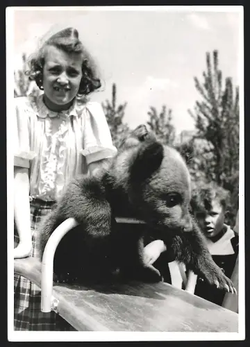 Fotografie junge Mädchen mit Bären Jungem auf einer Wippe