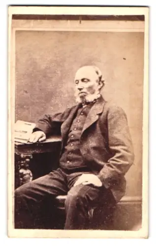Fotografie W.H. Simons, Braintree, Porträt eines älteren Herrn am Tisch