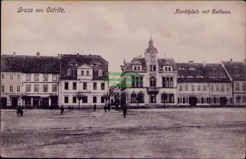 169003 AK Ostritz 1906 Magazin für Haus und Küchengeräte Marktplatz mit Rathaus