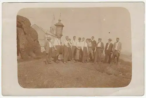 Gruppenbild von 13 Männern vor Marterl und Kirche.