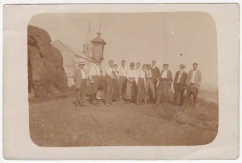 Gruppenbild von 13 Männern vor Marterl und Kirche.