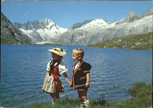 Grimsel Tr?bensee mit Trachtenp?rchen Kat. Grimsel