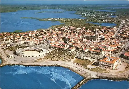 Saintes-Maries-de-la-Mer Vue aerienne La Ville les Arenes l'Eglise Au fond les etangs /  /