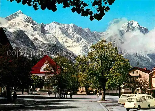 AK / Ansichtskarte Garmisch Partenkirchen Marktplatz mit Spielban gegen Zugspitzgruppe Kat. Garmisch Partenkirchen