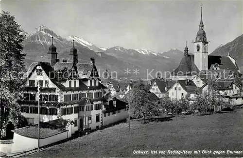 AK / Ansichtskarte Schwyz Ital von Reding Haus mit Blick gegen Brunnen Kirche Alpen Kat. Schwyz