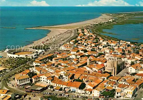 AK / Ansichtskarte Les Saintes Maries de la Mer Vue aerienne de la vitte Eglise fortifiee Les arenes