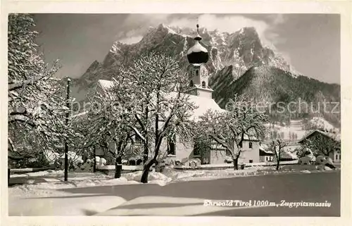 AK / Ansichtskarte Ehrwald Tirol Ortsansicht mit Kirche Winterpanorama Zugspitzmassiv Wettersteingebirge