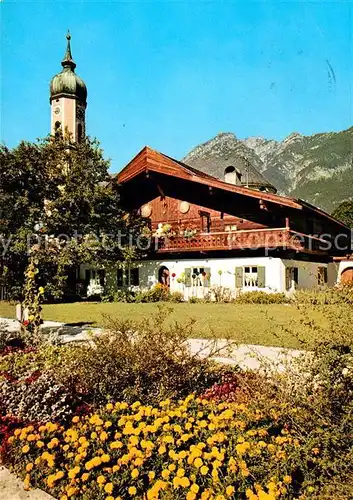 AK / Ansichtskarte Garmisch Partenkirchen Pfarrkirche mit altem Bauernhaus Kat. Garmisch Partenkirchen