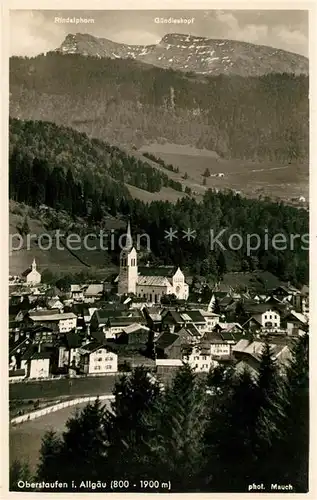 AK / Ansichtskarte Oberstaufen Ortsansicht mit Kirche Blick gegen Rindalphorn und Guendleskopf Allgaeuer Alpen Kat. Oberstaufen