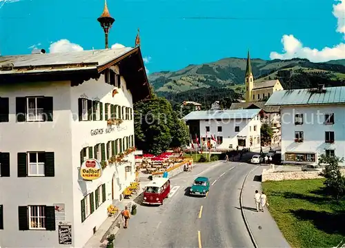 AK / Ansichtskarte Kirchberg Tirol Strassenmotiv mit Gasthaus Kalswirt gegen Hahnenkamm Kat. Kirchberg in Tirol